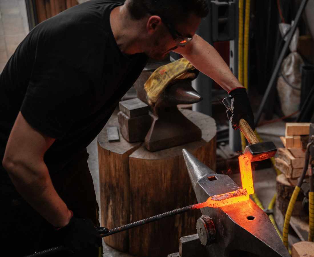 Messerschmiede Jettenbach Schmiedekurs Damastmesser Dies ist ein Foto des Schmieds der Messerschmiede Jettenbach bei der Arbeit während eines Schmiedekurses, um Damastmesser selber zu machen.