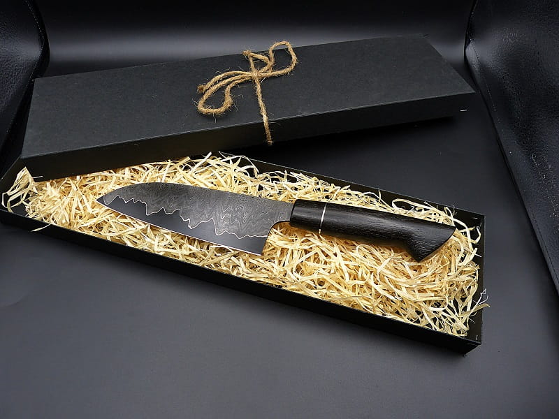 121 A Santoku with a Go-Mai construction, featuring wild Damascus steel and a nickel liner. The handle is crafted from stabilized bog oak and nickel silver.