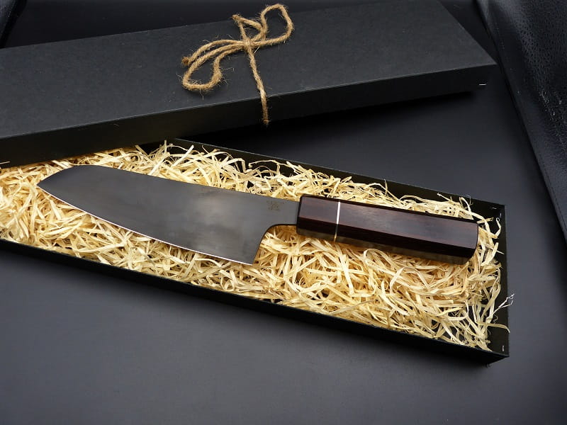 A Santoku made of 1.2235 steel, with a handle of Makassar ebony and nickel silver.