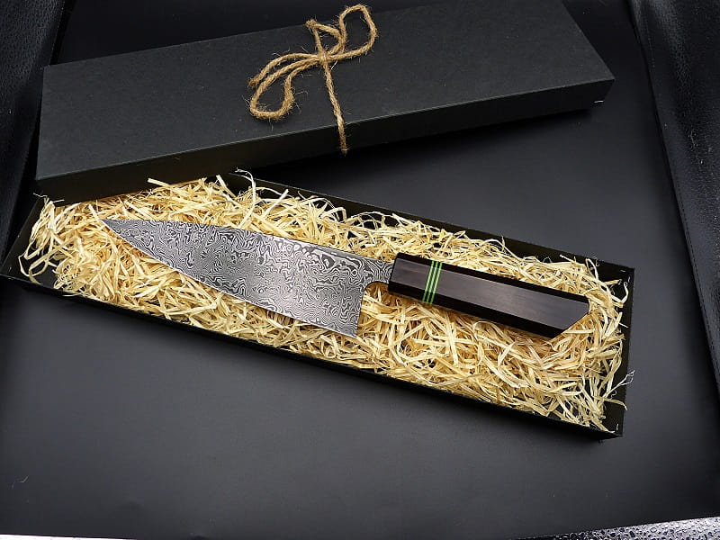 A chef's knife made of wild Damascus steel, with a handle of Grenadilla and G10.